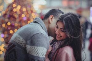 Romantic couple sharing a warm moment under golden lights, inspiring the love poem “Whisper Beneath the Lights” on deeplovepoems.com.